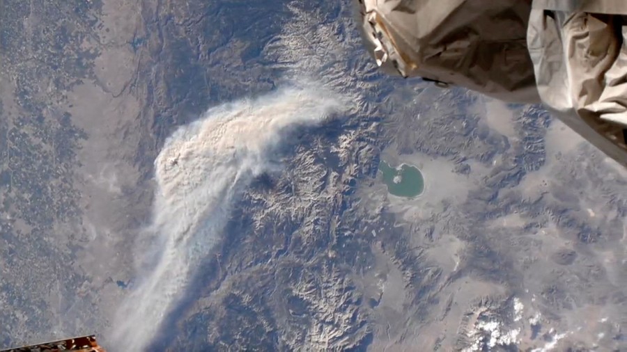 A view of a cloud of spreading smoke, seen from aboard the International Space Station.
