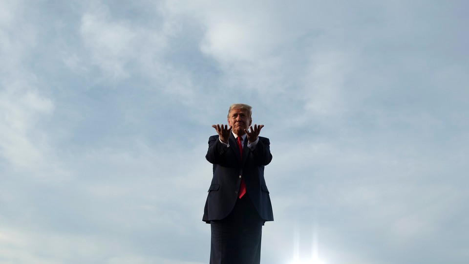 Donald Trump stands against a blue sky, gesturing toward the viewer.
