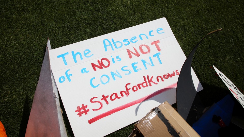 A sign reads "The absence of no is not consent. #Stanfordknows"