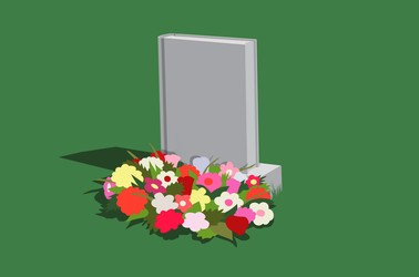 A gravestone that looks like a book with flowers at its base