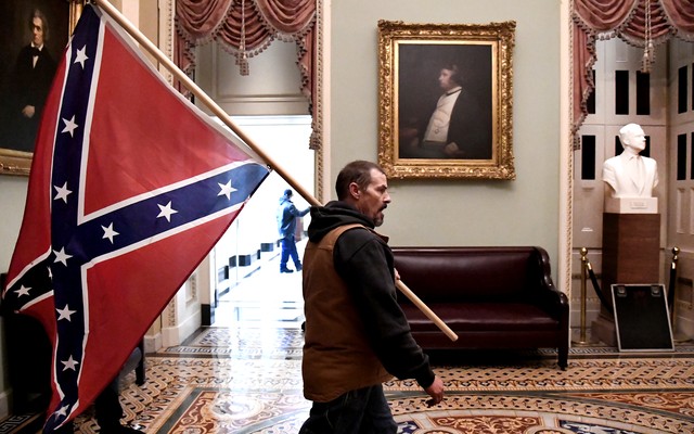 A Trump supporter carrying a Confederate flag through the U.S. Capitol.