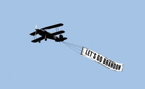 A propeller plane pulls a banner saying "Let's go Brandon"