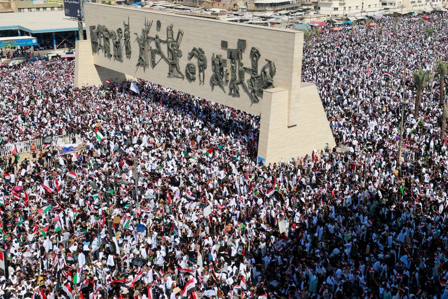 An elevated view of a large crowd of people gathered in a city square