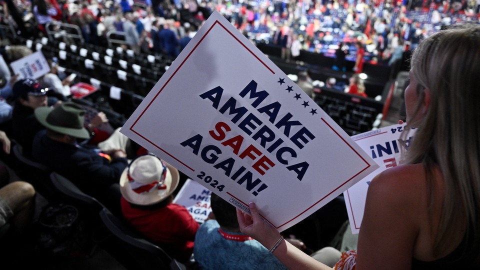 An attendee holds a "Make America Safe Again" sign during the second day of the 2024 Republican National Convention