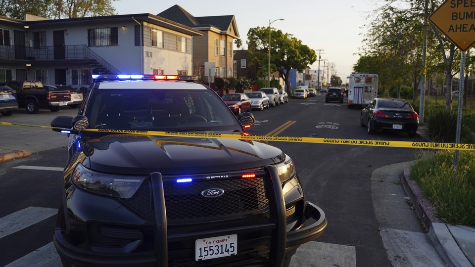 A photo of a police car near yellow crime scene tape