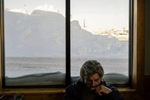 Karl Ove Knausgaard sits before a window.