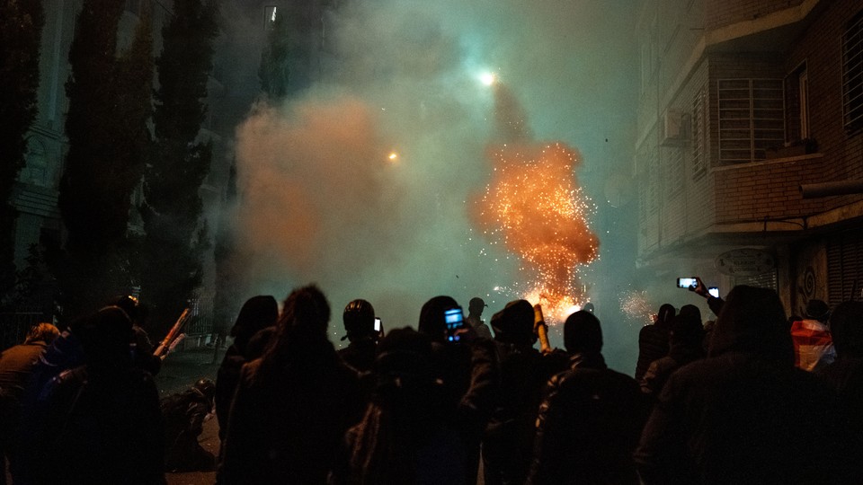 An image of protesters in front of the Georgian Parliament throwing fireworks