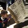 A 3-year-old boy carries a sign opposing Betsy DeVos`