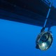 An underwater microphone hangs from a boat