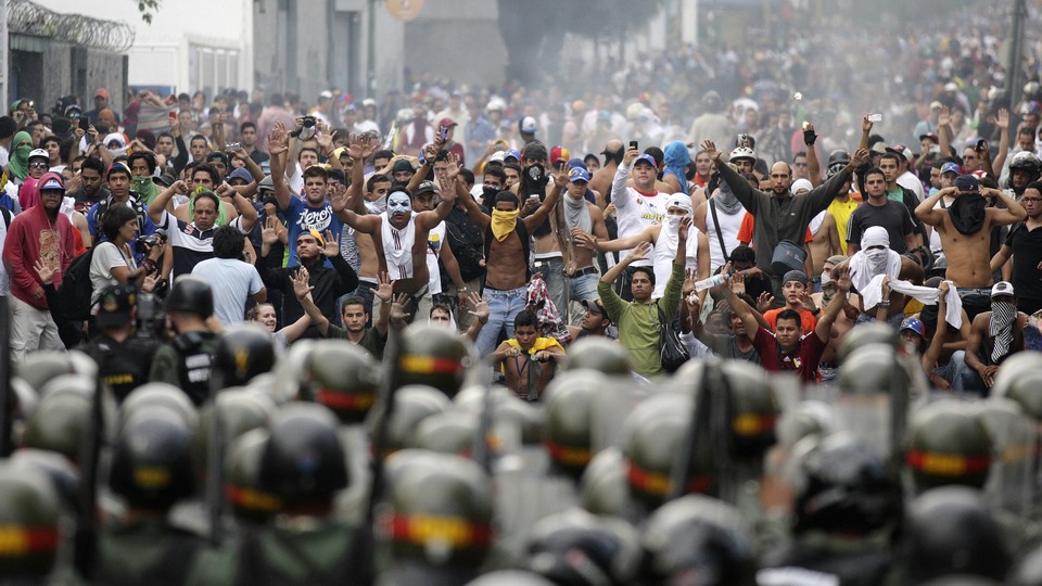 Supporters of opposition leader Henrique Capriles face off against riot police in Caracas.
