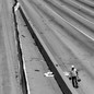 Black-and-white photo of a construction worker on an empty highway