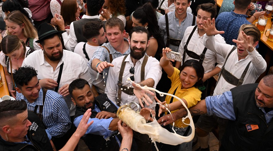 A crowd reacts as a beer mug spills above them.