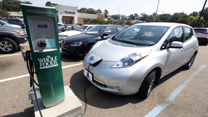 An electric vehicle at a Whole Foods–branded charging station