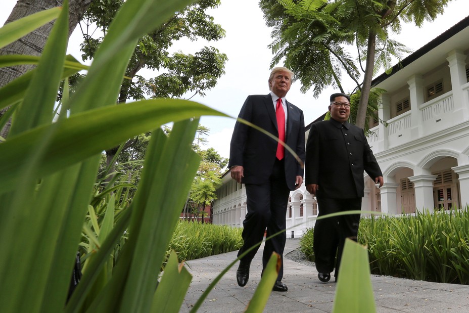 U.S. President Donald Trump and North Korea's leader Kim Jong Un walk together before their working lunch during their summit at the Capella Hotel on the resort island of Sentosa, Singapore.