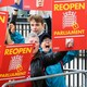 Protestors with signs that say "REOPEN PARLIAMENT"