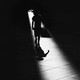 Illustration of a little boy walking in darkness, a sliver of light illuminating him