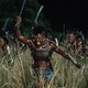 Viola Davis and other woman charging through a field as warriors in "The Woman King"