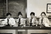 Women seated before microscopes in an undated photo