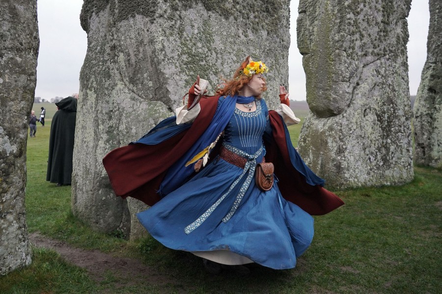 A woman dances between stones at Stonehenge.