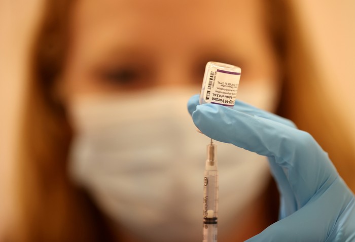 A pharmacist fills a syringe with the Pfizer COVID-19 booster vaccine.