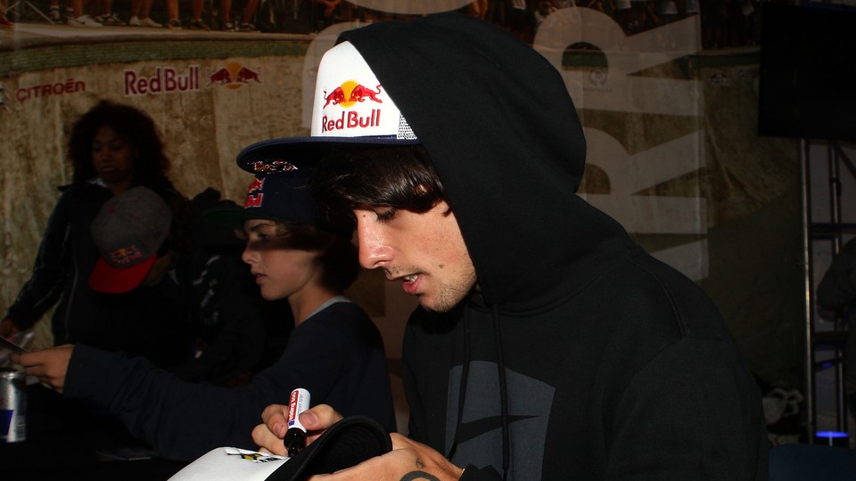 An X-Games athlete signs autographs at the event's Red Bull tent.