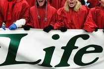 Protesters holding a sign that says "Life"