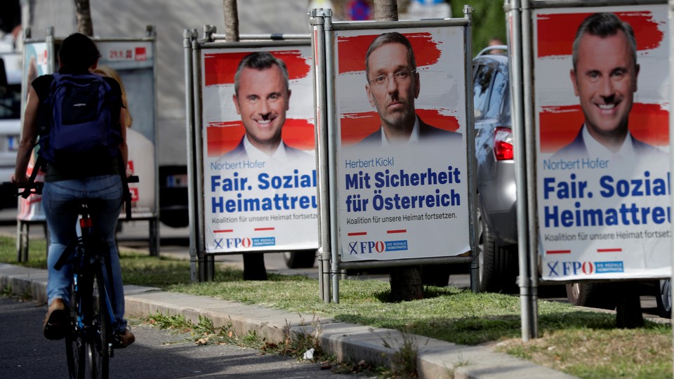 A cyclist passes posters featuring the far-right Freedom Party leader, Norbert Hofer, and former Interior Minister Herbert Kickl in Vienna.