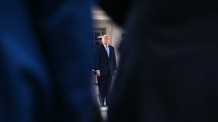 Trump showing through a navy blue courtain