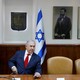 Benjamin Netanyahu sits in his office in front of a portrait of the Zionist leader Theodor Herzl.