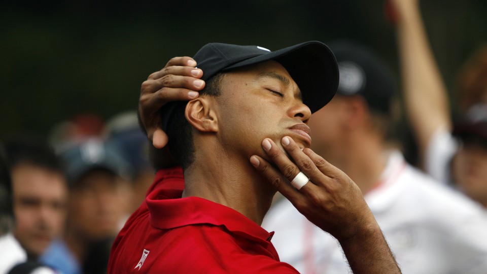 Tiger Woods stretches his neck as he plays during the final round of the 2009 HSBC Champions golf tournament.