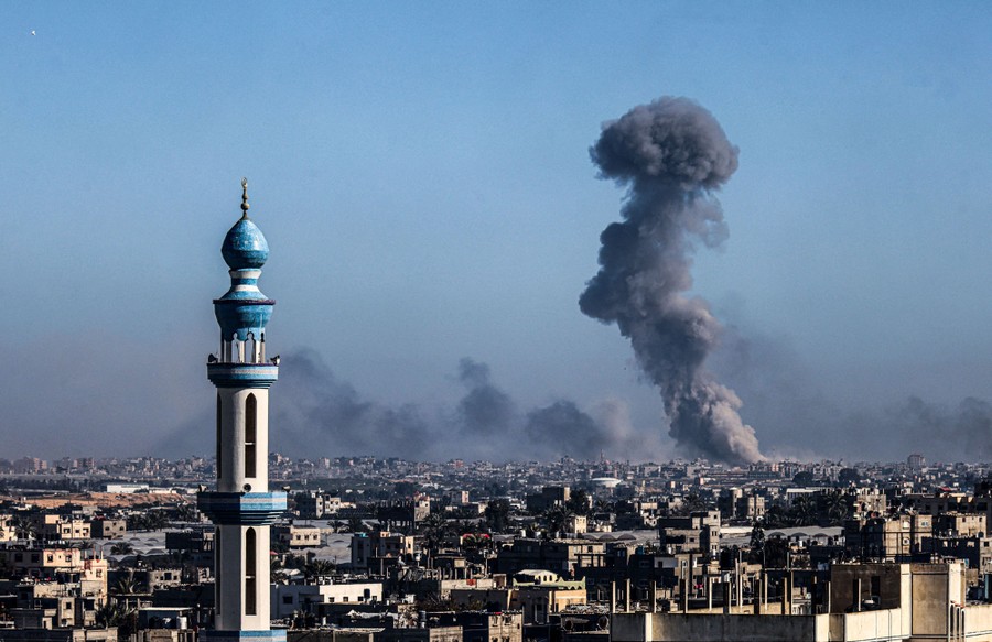 Smoke rises from an explosion in a Gaza neighborhood, seen from a distance.