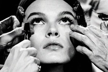 A close up of a woman having make up applied to her face