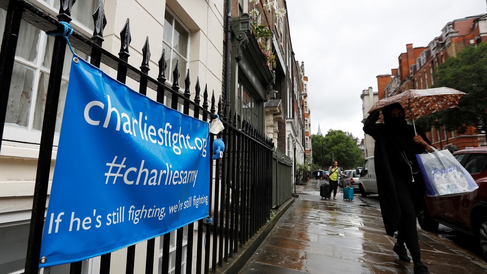 A woman walks past a banner left by supporters of Charlie Gard's family on July 27, 2017. 