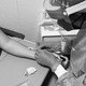 a masked healthcare worker injects a monkeypox vaccine intradermally into a woman's arm. the needle is entering almost horizontal to the arm so it can be shallow.