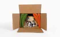 A cardboard box contains a collection of artifacts, including a photo of Malcolm X