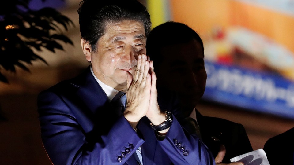 Prime Minister Shinzo Abe closes his hands in thanks at a campaign rally.