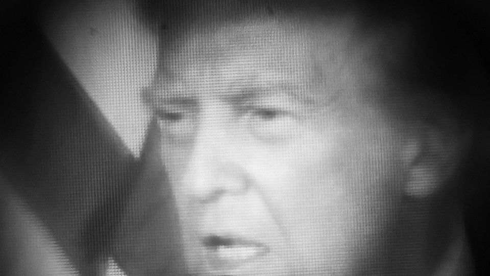 Pixelated black-and-white photograph of Donald Trump with an American flag behind him