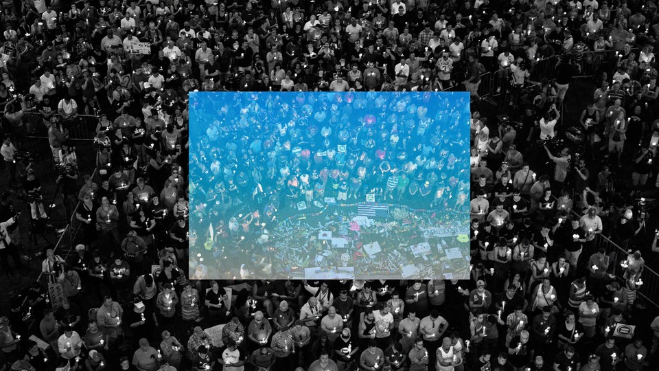 Black-and-white photo of a crowd of mourners with a square blue overlay in the middle