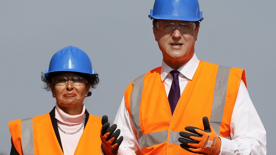 Anne Marie Morris stands alongside former Prime Minister David Cameron in Devon, England on April 10, 2015. 