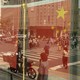 Chinese flags and pedestrians reflected in a window in Shanghai, China