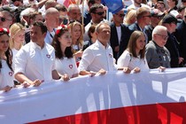 Peaceful protesters holding a big Polish flag