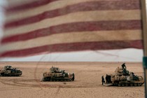 A photograph of tanks with an American flag in the foreground