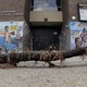 A broken tile mural that reads "We Ought to Protect Our Neighbors And" 