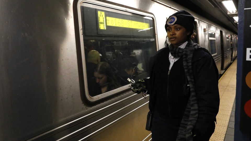 A conductor stands next to a stalled train in New York City after a power failure stopped multiple subway lines in April 2017.