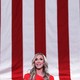 Lara Trump in front of a flag background