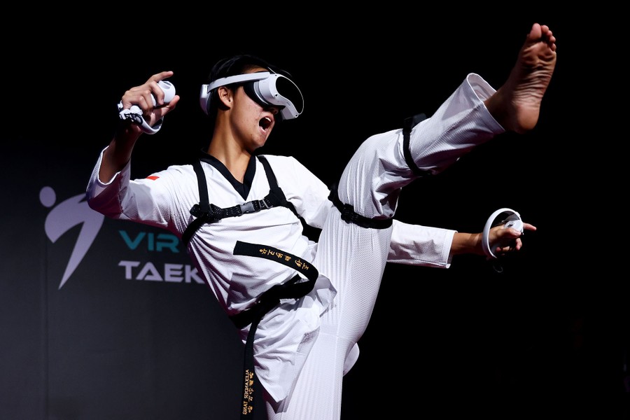 A martial artist performs onstage while wearing a virtual-reality headset.