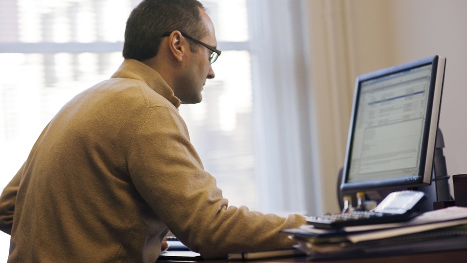 A man checks his email on his desktop computer.