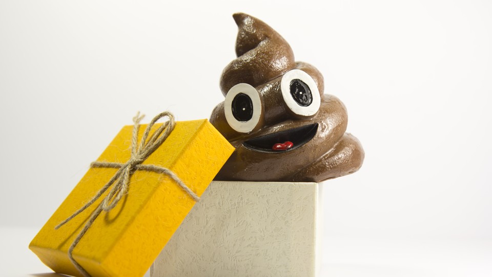 A smiling, cartoonish pile of poop next to a gift-wrapped box