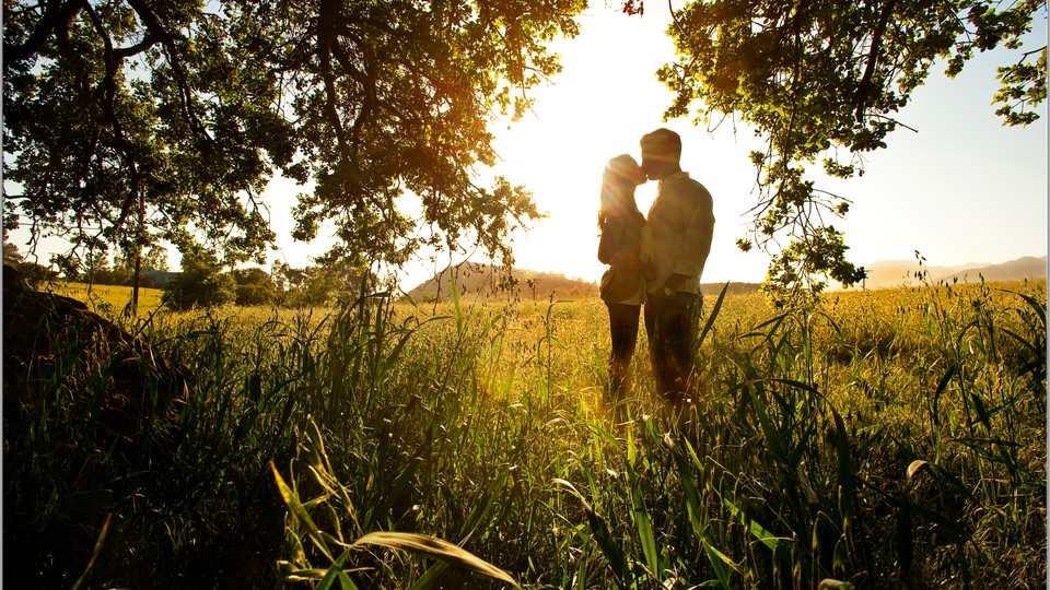A couple kissing in a field