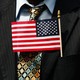 An American flag worn in a suit pocket during a naturalization ceremony